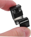 Gas tank door spring clip, black plastic housing with metal band, shown in close-up between fingers.