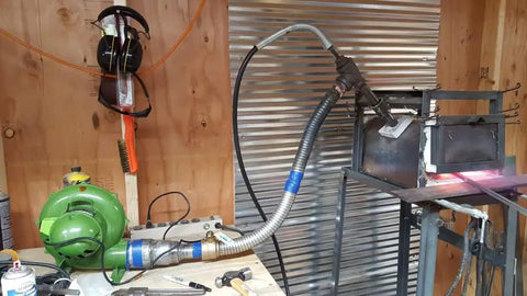 Electric Blacksmith Forge Blower 110V 250W For Coal Fires setup in a workshop with tools and connected to a coal forge system.