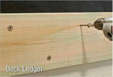 Deck ledger being fastened with a structural wood screw using a drill.