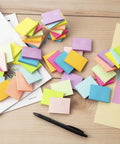 Small 1.5x2 Inch Sticky Notes, 50 Pads With 50 Sheets Each, 10 Bright Colors on desk with pen and papers