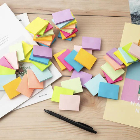 Small 1.5x2 Inch Sticky Notes, 50 Pads With 50 Sheets Each, 10 Bright Colors on desk with pen and papers