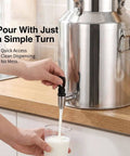 Heavy Duty 1.3 Gallon To 26.4 Gallon Stainless Steel Milk Can With Black Spigot dispensing milk into a glass.