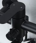 Close-up of matte black wall mount kitchen faucet control, part of heavy duty stainless steel commercial mixer tap