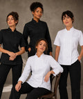 Womens Short Sleeve Double Breasted Black Chef Coat Featuring Ten Pearl Buttons And Tailored Kitchen Fit modeled by four women.