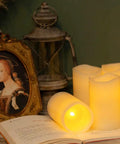 Flickering Flameless LED Candles Real Wax Pillar Set Of 6 with ambient glow, displayed next to vintage décor, battery operated