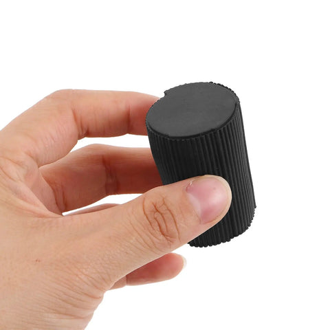 Hand holding black plastic foot pad from 8 Pack Round Non Slip Piano Stand Foot Pads For Digital Keyboard Floor Protection Stable Base Grippy Leg Caps