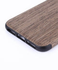 Wooden phone case close-up with dark accents and sleek finish, showcasing texture and durability
