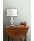 Badass Country Sage Green Matte Linen Wallcovering Pvc Free Heavy Duty Covering in a home setting with lamp and books.