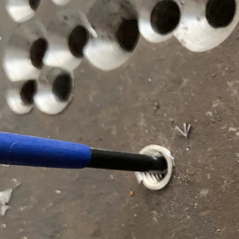 Close-up of M5 X 0.8 Helical STI Thread Repair Kit being installed with driver and tang in a metal surface for thread fix.