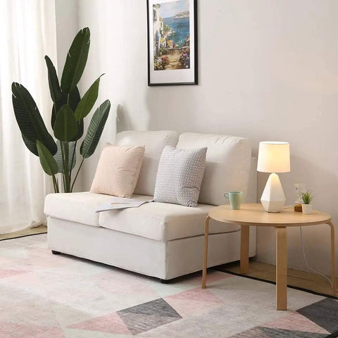 Modern White Ceramic Table Lamp With Irregular Geometric Base And White Fabric Shade on round table in living room setup