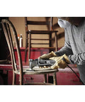 Person using Pro Grade Corded Oscillating Multi Tool Kit 120V 3.5 Amp Power, Reconditioned, on chair in workshop