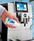 Milk System Cleaner Mini Tabs For Espresso Machines Easy One Step Cleaning For Froth Mastery Keeps Lattes Smooth No Fuss Clogs Prevention Fresh Milk Foam Every Sip, hand pouring cleaner into JURA espresso machine