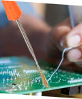 Close-up of Six Piece Soldering Assist Set Desoldering Pump And Wick Kit For PCBs with hands working on a circuit board.