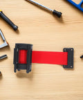 Heavy Duty Retractable Belt Barrier Wall Mounted Crowd Control Divider Featuring Smooth Gliding Telescoping Tape on a workbench.