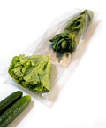 Compact Horizontal Flow Wrapper Shrink Wrap Machine 50 To 80 Pieces Per Minute wrapping fresh lettuce and greens in clear film.