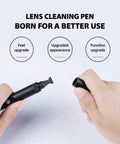Front view of black VSGO Professional Lens Cleaning Pen with cap off, brush end visible, held by hands.