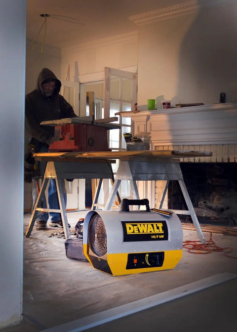 Heavy Duty 10 Kilowatt Forced Air Electric Construction Heater in use on a job site with a worker at a wood cutting table.