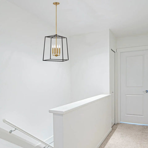 Dope Two Tone Farmhouse 4 Light Pendant Chandelier in black and warm brass hanging in a white hallway with geometric metal cage design.