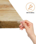 Hand holding clear PVC corner protector from 16 pack for furniture and cabinets, easy install safety corner guards with cushioned edges.