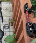 Close-up of Portable Bike Repair Stand For On The Go Maintenance, compact clamp bracket on wooden rail, with saddle and pedal visible