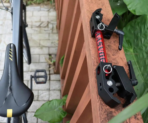 Close-up of Portable Bike Repair Stand For On The Go Maintenance, compact clamp bracket on wooden rail, with saddle and pedal visible