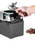 Absolute Knockout Electric Portafilter Cleaner And Automatic Espresso Puck Remover with wood handle and espresso beans.