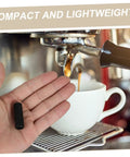 Hand holding Two Pack Steam Wand Safety Guards For Coffee Machines Rubber Steam Pipe Cover Insulation Sleeves Easy Install Protect Hands From Burns And Keep Your Espresso Maker Running Smoothly Coffee Accessory near an espresso machine.
