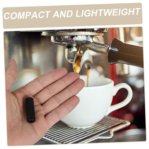 Hand holding Two Pack Steam Wand Safety Guards For Coffee Machines Rubber Steam Pipe Cover Insulation Sleeves Easy Install Protect Hands From Burns And Keep Your Espresso Maker Running Smoothly Coffee Accessory near an espresso machine.