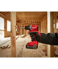 M18 Trade Compact Brushless Two Tool Combo Kit With Drill Driver And Impact Driver Includes Two RedLithium Batteries And Multi Voltage Charger For Pro Grade Power On The Go being used on wooden beams in construction site