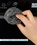 Hand using Heavy Duty Stainless Steel Scrubber Pad on oven surface, 2.4 inch ergonomic, durable spiral wire, 12 pack, rust-resistant.
