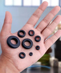 Hand holding 180 Pcs Rubber Grommets Kit In Eight Sizes For DIY Auto Wiring And Cable Protection Drill Hole Sizes One Quarter Inch Through One Inch Premium Flexible Rubber Grommets Assorted Set