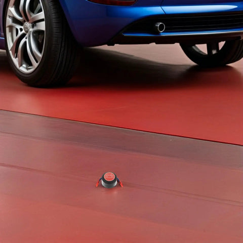 Compact Automatic Aerosol Fire Extinguisher Kit For Car Engines And Garages on red floor near car tire.