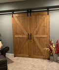 Installed Double Gate Sliding Barn Door Hardware Kit With 15 Foot Track And 12 Inch Door Handles in a living room.