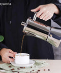 Heavy Gauge Stainless Steel Stovetop Espresso Maker And Legit Italian Moka Pot For 4 Cups pouring coffee into a cup.