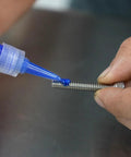 Permatex blue 6 ml medium-strength threadlocker applied to a metal threaded bolt