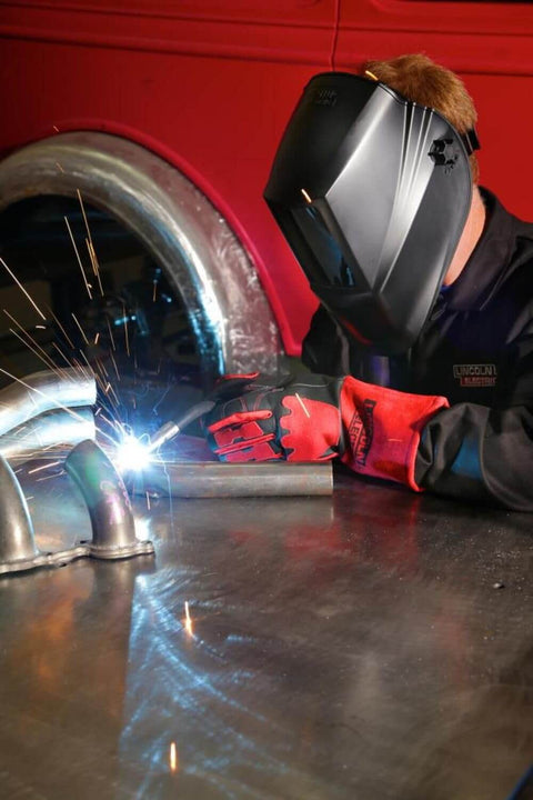 Person wearing K2800-1 4.5 By 5.25 Inch Auto Darkening Weld Helmet With Grade Ten Lens working on metal pipe welding.