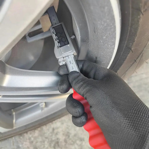 Measuring with Digital Disc Brake Rotor Caliper with Large LCD Screen, hand holding tool near brake rotor.