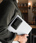 Man carrying laptop with attached On The Go Portable SSD Sleeve For Laptop With Reusable Adhesive Grab And Go External Drive Carrying Case Pocket