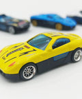 Close-up of a yellow diecast car model with 10 Pack 1/64 Diecast Car Wheels And Tires Set With Mixed Rubber Tires, visible on display.