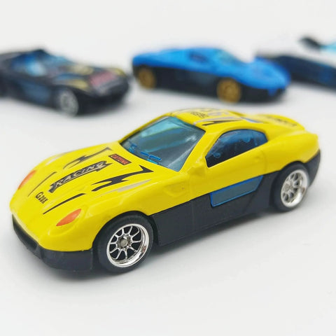 Close-up of a yellow diecast car model with 10 Pack 1/64 Diecast Car Wheels And Tires Set With Mixed Rubber Tires, visible on display.