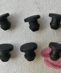 Black Silicone Rubber Washers Kit For Home Repairs, Durable Snap-On Hole Plugs And Gasket Seals That Fit Cracks Perfectly To Stop Leaks Fast. Black silicone snap-on hole plugs shown on fabric, six-piece rubber gasket seals for home repairs.