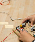 Hands assembling fruit battery with Copper And Zinc Electrode Strips 20 Pcs DIY Science Kit For Classrooms And Labs, Fruit Battery Projects.
