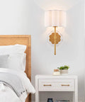 Bedroom view of set of 2 modern wall sconces with creamy white fabric flower shades and antique brass brush finish, UL listed