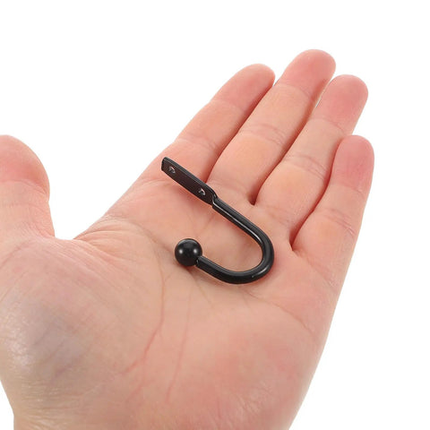 Grab These Bad Boys 12 Pack Black Mini Metal Wall Mount Coat Hooks For Doors And Walls Vintage Style Single Prong Design held in hand.