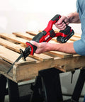 Person using a reciprocating saw from 4 Tool Power Kit With 20V Cordless Drill Driver Impact Driver Reciprocating Saw And LED Spotlight