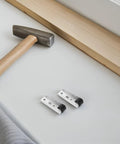 Top Shelf Heavy Duty Sliding Door Track Rollers With Silky Smooth Swivel Caster Wheels For Closet Cabinet Wardrobe Furniture Silent Zero Hassle Black Composite Four Piece Set displayed with a hammer and wood.