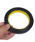 Hand holding one roll blackout tape for windows that blocks LED light and dims screens with heavy duty adhesive window covering.