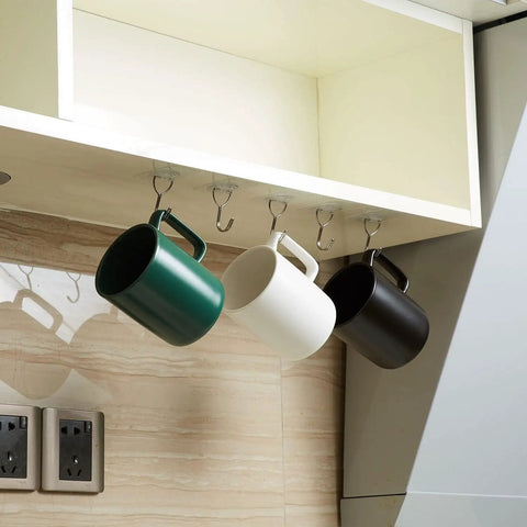 8 Pack Clear Adhesive Wall Hooks Stick On Self Adhesive Stainless Steel Hooks Hang Up To 11 Lbs Great For Bathroom Kitchen Entryway And More Discreet Invisible Mount No Tools Needed holding mugs under a shelf.