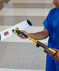 Man holding a Straight Up Heavy Duty 17 Inch Silver Microfiber Mop Frame with Quick Connect for industrial janitorial work.