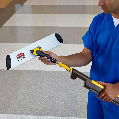 Man holding a Straight Up Heavy Duty 17 Inch Silver Microfiber Mop Frame with Quick Connect for industrial janitorial work.